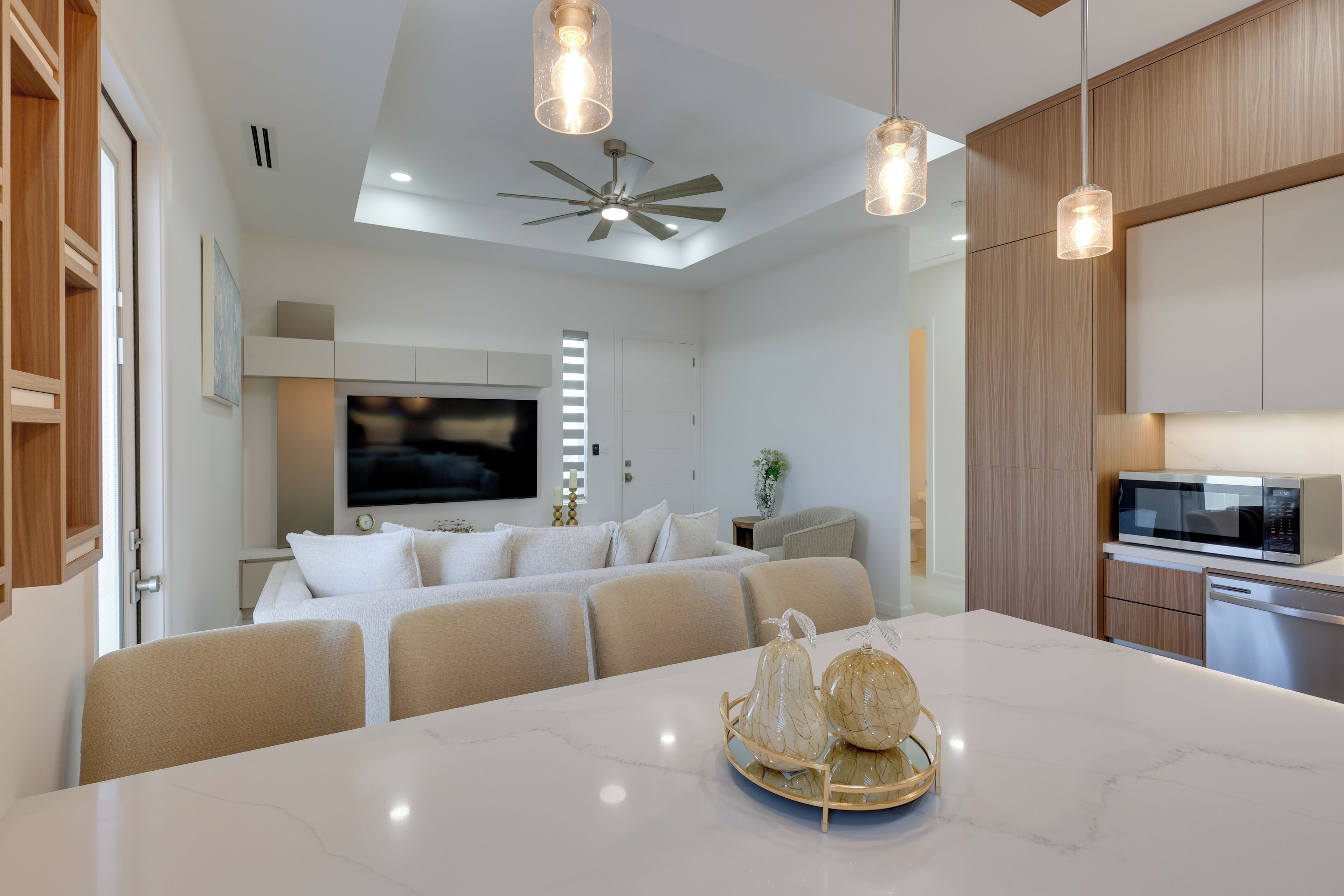 A modern kitchen with a large island, built-in appliances, and pendant lighting.