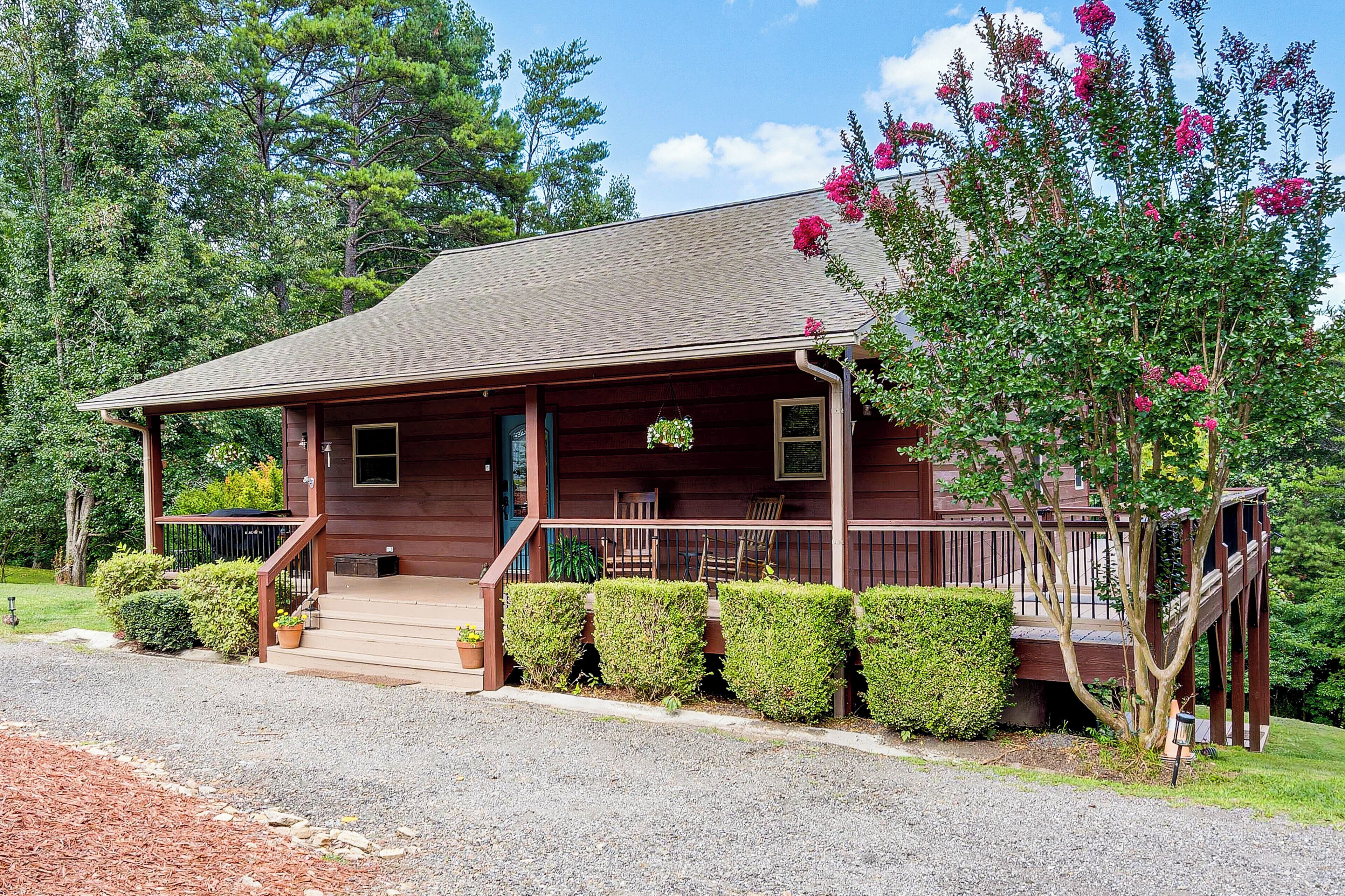 A wooden cabin with a porch, steps, and a small garden.