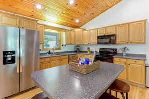 A modern kitchen with wooden cabinets, stainless steel appliances, and a granite countertop. - Serene Wooded Cabin w/ Decks, 4 Mi to Dtwn Murphy (Murphy)