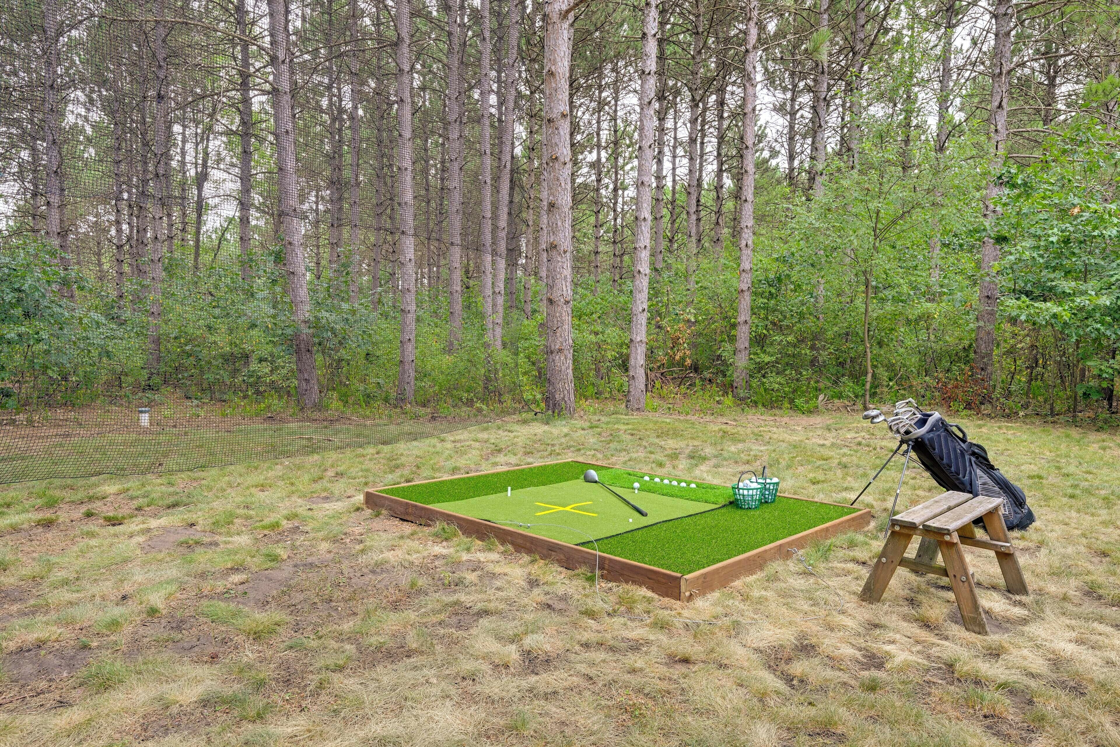 Um campo de minigolfe com um banco de madeira e um saco de bolas de golfe.
