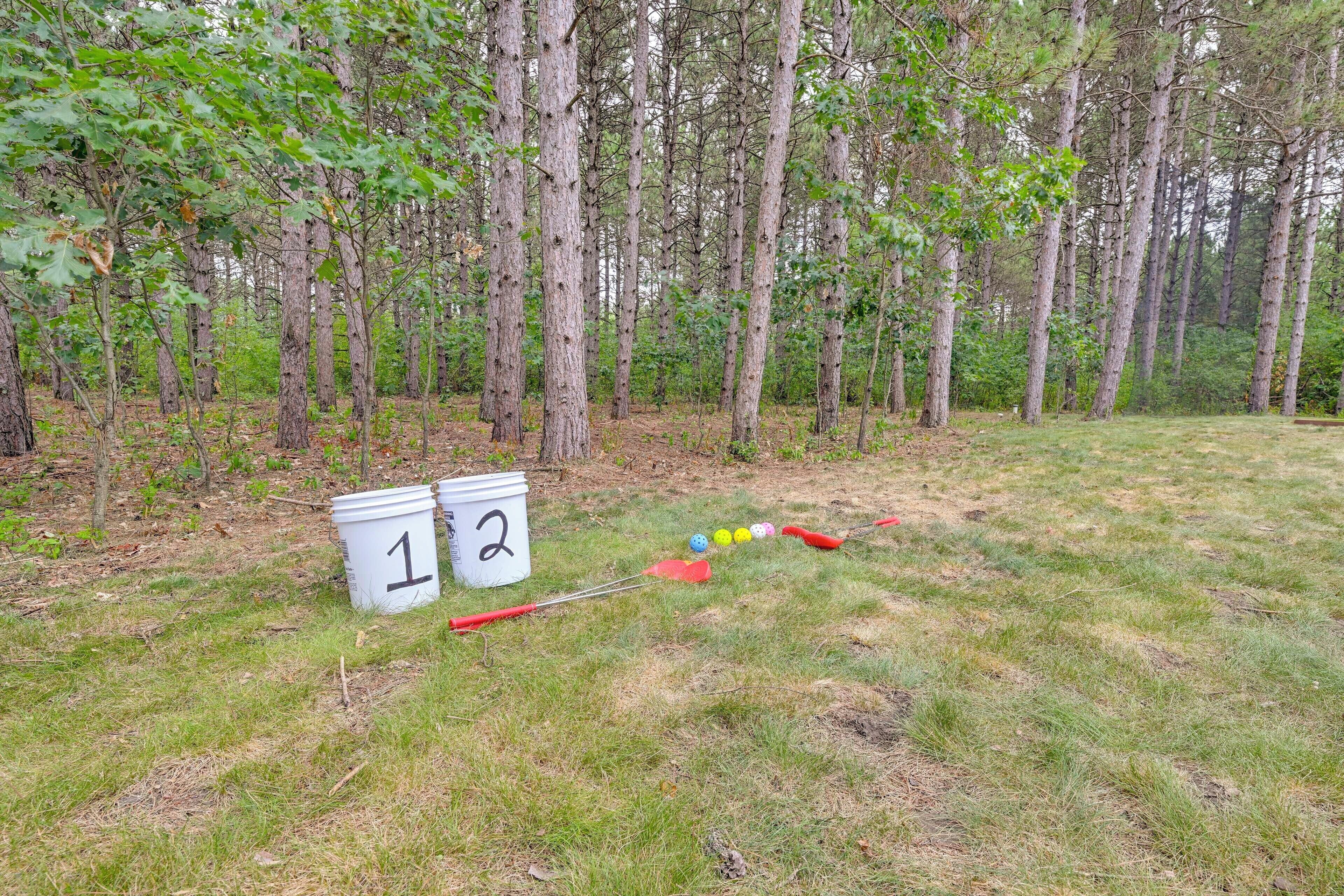 Zona boscosa con cubos numerados y un juego de croquet.