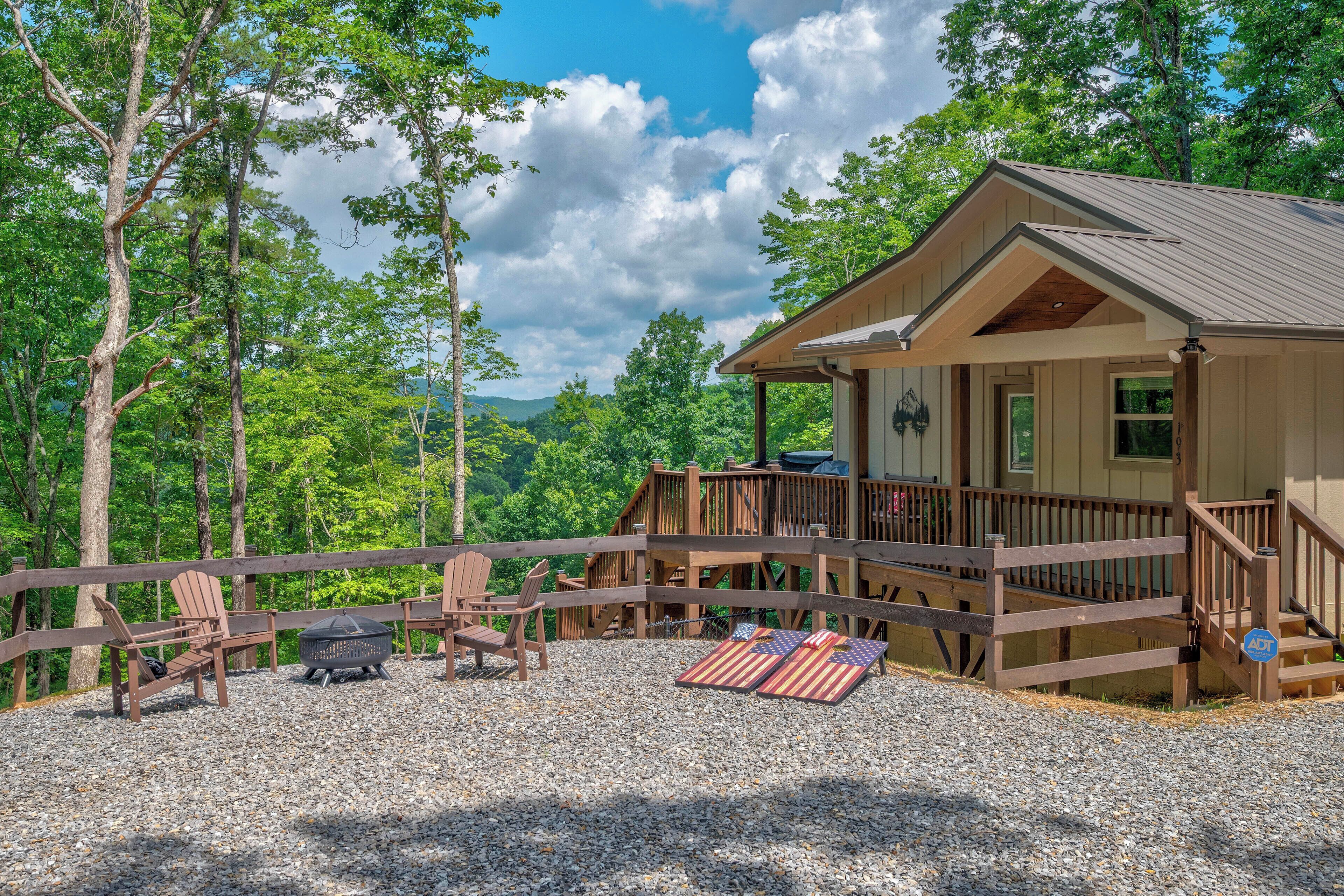 A cabin with a deck, outdoor seating, and a fire pit.