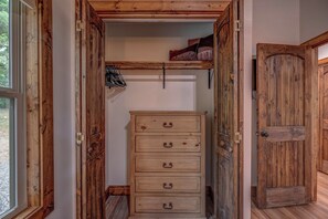 A wooden wardrobe with five drawers, a shoe rack above it, and a wooden door to the right. - Blue Ridge Views, Hot Tub! Murphy Mtn Cabin (Murphy)