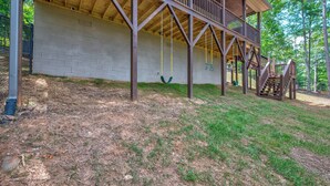 A wooden deck with a swing set and a staircase leading to a covered area. - Blue Ridge Views, Hot Tub! Murphy Mtn Cabin (Murphy)