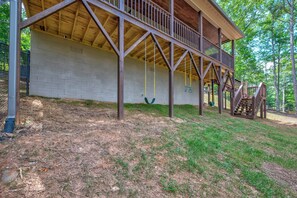A wooden deck with a swing set and a staircase leading to a covered area. - Blue Ridge Views, Hot Tub! Murphy Mtn Cabin (Murphy)