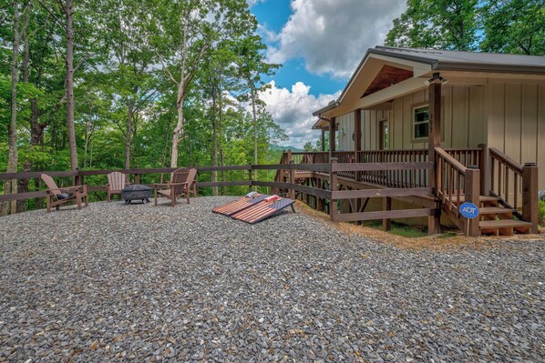Een chalet met een grindpad, een houten terras en een overdekte veranda.