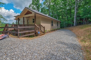 A single-story cabin with a porch, a gravel driveway, and a forested backdrop. - Blue Ridge Views, Hot Tub! Murphy Mtn Cabin (Murphy)