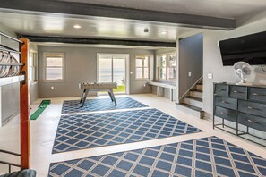 A room with a pool table, a sofa, a TV, and a staircase. - Lakefront Family Getaway on Willsboro Point! (Willsboro)
