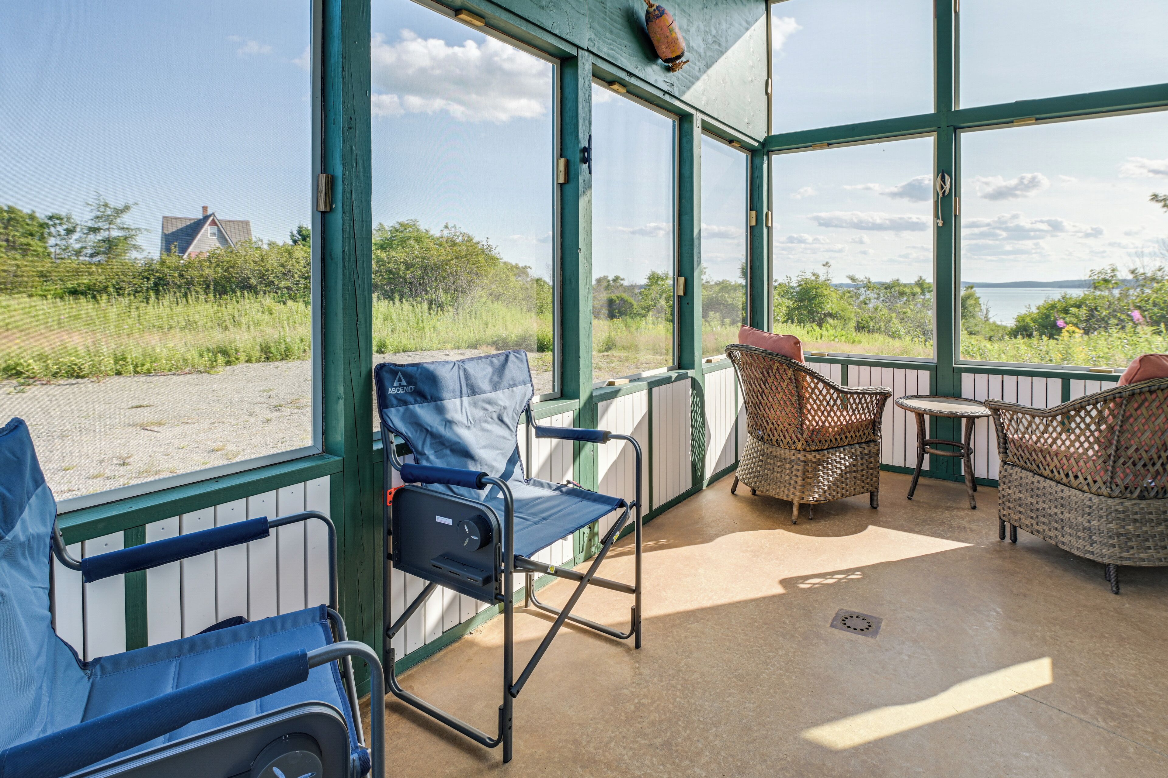 A covered outdoor seating area with a view of the beach and sea.