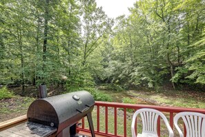 A barbecue grill on a deck overlooking a forested area with a river. - Great for Families! Wolf pen Gap ATV Base on Creek (Mena)