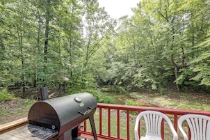 Una parrilla en una terraza con vistas a un área boscosa y un río.