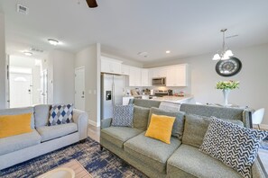 A modern living room with a grey sofa, yellow cushions, and a blue patterned rug. - Great for Groups! 2 Centrally Located Concord Gems (Concord)