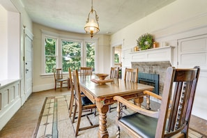A dining room with a wooden table, chairs, a chandelier, and a fireplace. - Yakima Wine Country! Orchards & Hop Yard On-site (Wapato)