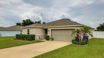 A single-story house with a garage, a front lawn, and a driveway.