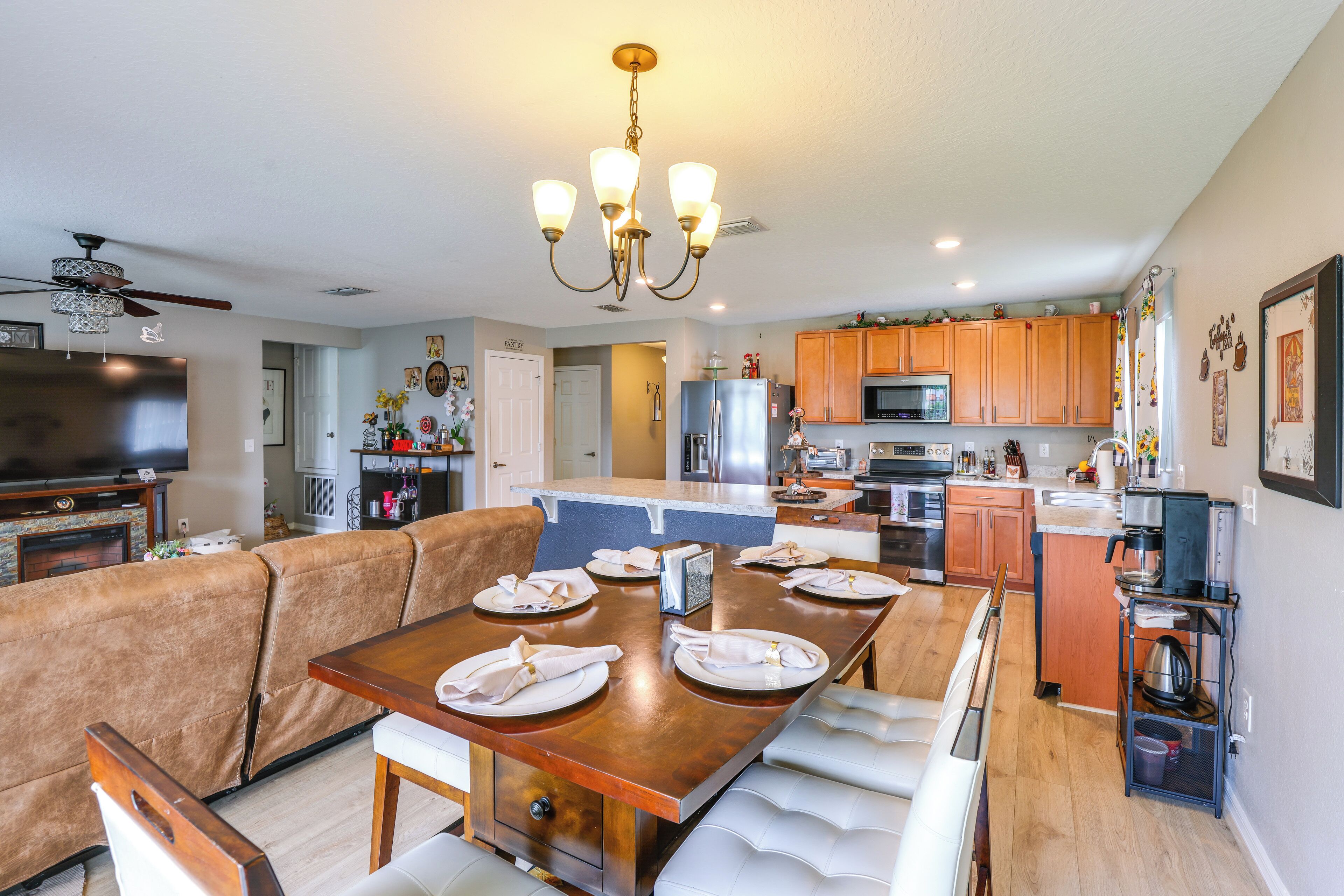A modern kitchen with wooden cabinets, a stainless steel refrigerator, and a built-in microwave.