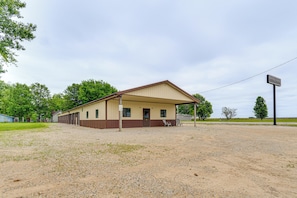 A single-story building with a covered porch, a gravel driveway, and a sign indicating 'Montrose Storage.' - Montrose Studio Getaway w/ Covered Patio (Montrose)