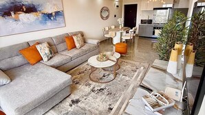 En moderne stue med sofa, sofabord og dekorative puder.