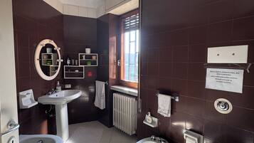 Ein Badezimmer mit Badewanne, Waschbecken, Toilette und einem Waschtisch mit Spiegel.