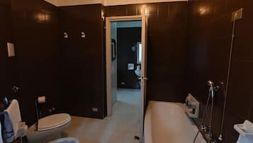 Une salle de bain moderne équipée de toilettes, d’un bidet et d’une baignoire.