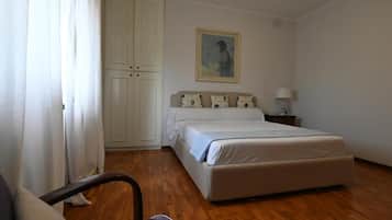 Une chambre à coucher avec un lit, une chaise, une armoire et un tableau au mur.
