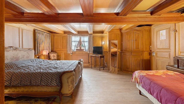 A traditional bedroom with a double bed, a smaller bed, a desk with a chair, and a wardrobe. - Gîte Gretel with Shared Terrace, Garden, and Wi-Fi (Bossendorf)