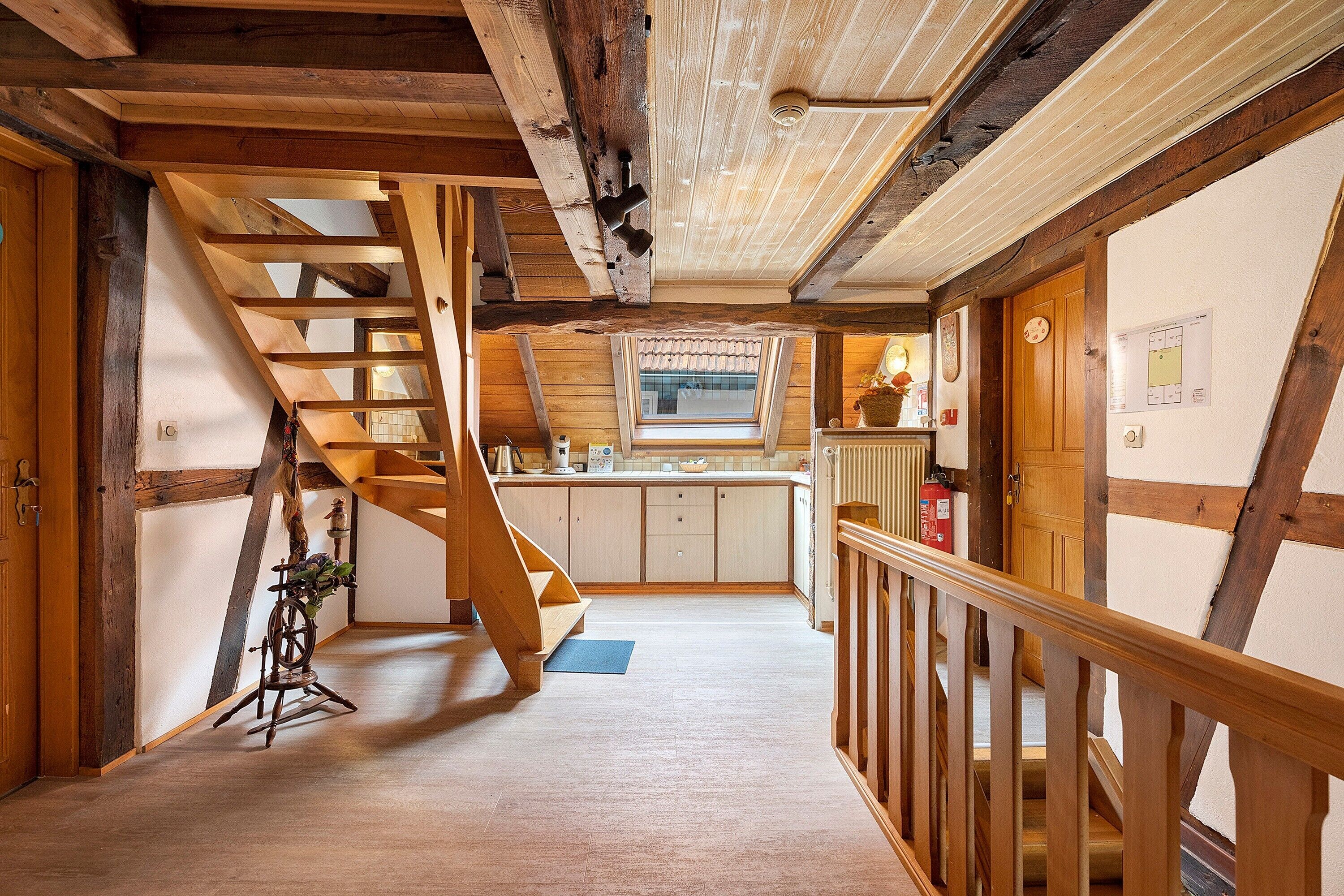 Een houten interieur met een trap naar een keuken.