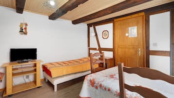 Een kamer met een bed, bureau, televisie en kledingkast.