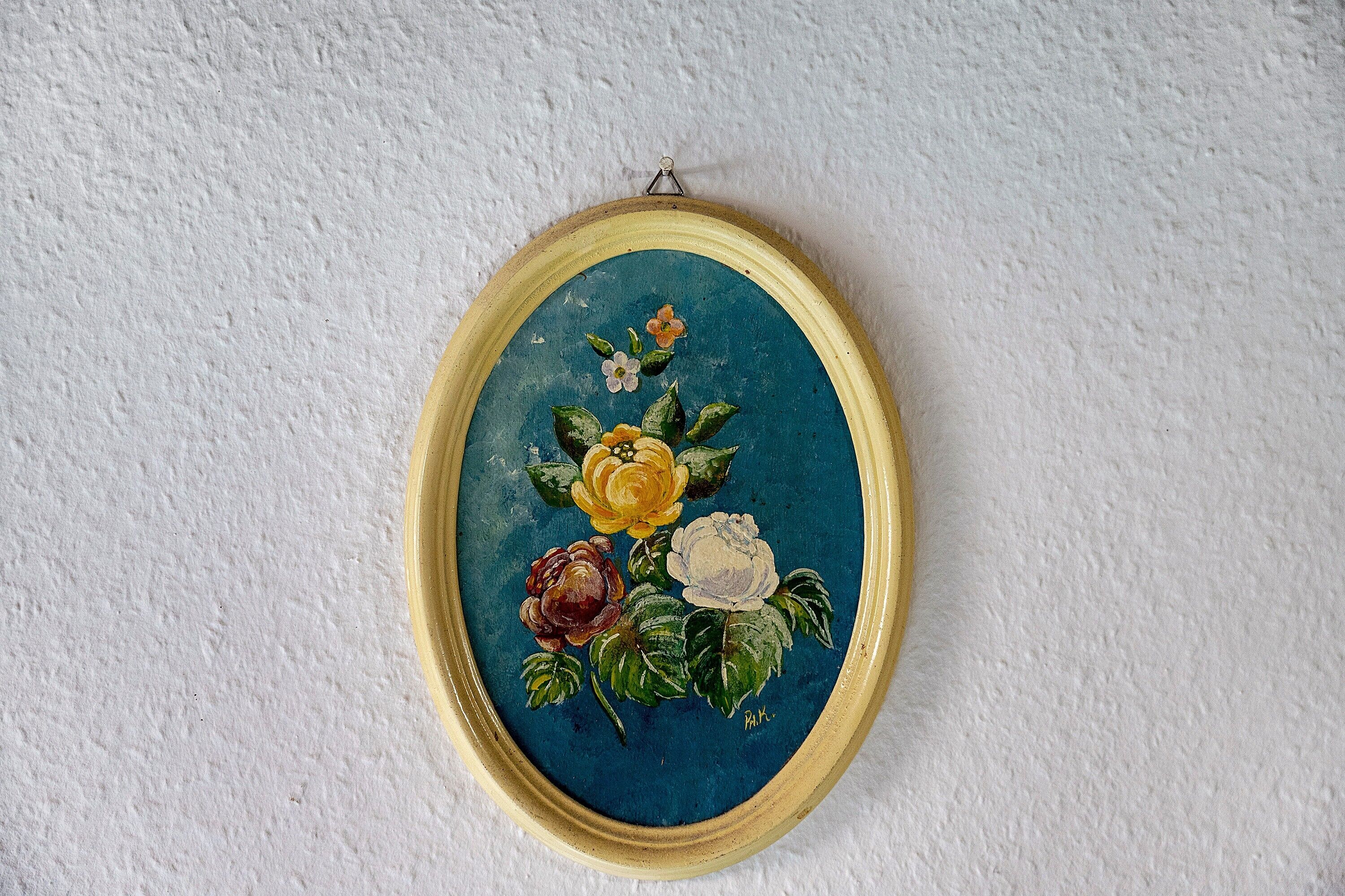 Une œuvre d’art florale encadrée, accrochée à un mur à texture.