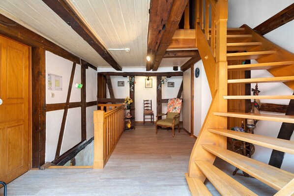 A wooden staircase leading to a second floor with a view of the interior.