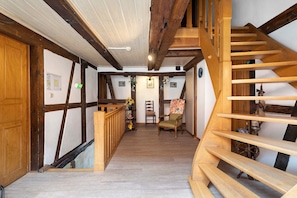 A wooden staircase with a handrail leading to a landing.