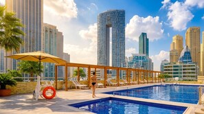 A rooftop pool area with lounge chairs and a view of tall buildings. - Vogue, Dec Tower Marina near Ain Dubai and JBR (Dubai Marina)