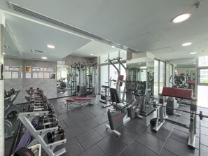 A gym with various exercise equipment, mirrors, and a tiled floor. - Vogue, Dec Tower Marina near Ain Dubai and JBR (Dubai Marina)