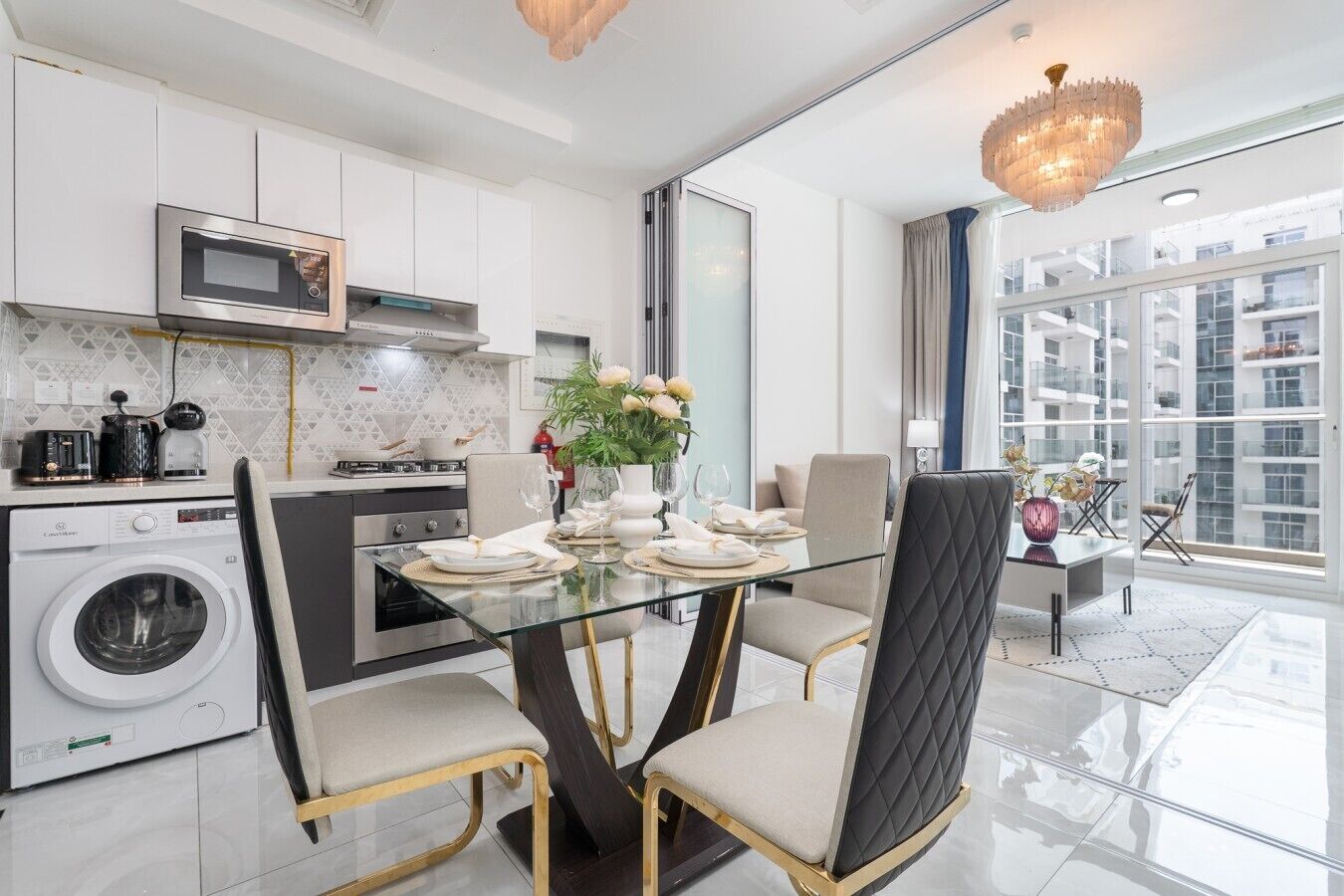 Una cucina moderna con zona pranzo, elettrodomestici in acciaio inossidabile e un'ampia finestra che offre vista sulla città.
