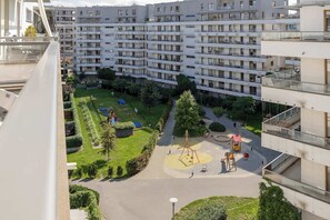 A residential building with multiple balconies, a playground, and a well-maintained garden. - Klimatisiertes Apartment | Parkplatz | Warschau-Wola (Warszawa)