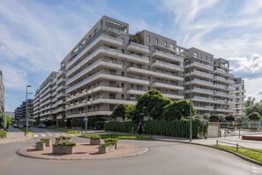 A multi-story residential building with balconies, a pedestrian crossing, and a roundabout. - Klimatisiertes Apartment | Parkplatz | Warschau-Wola (Warszawa)