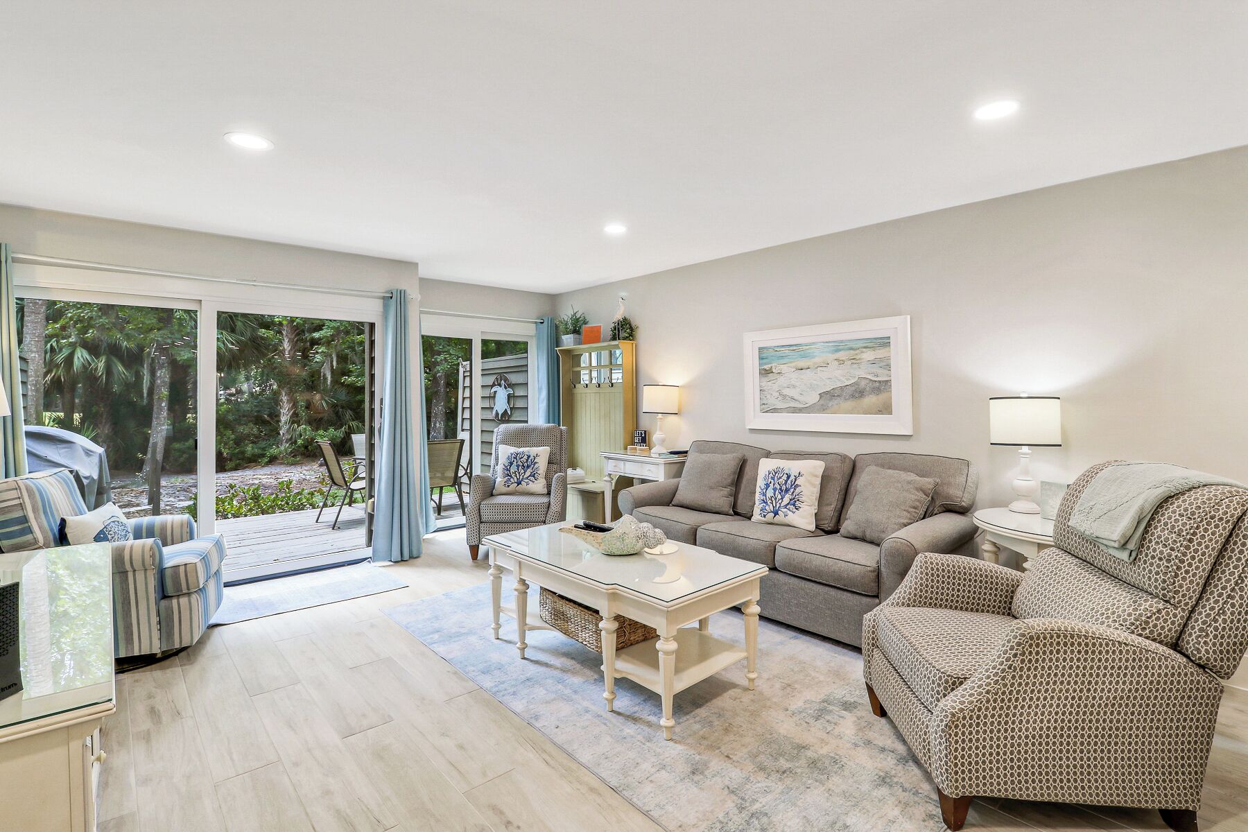 A spacious living room with a sofa, armchairs, a coffee table, and a dining area.
