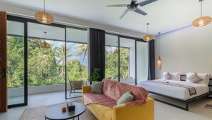 A modern bedroom with a bed, a sofa, and a dining table.