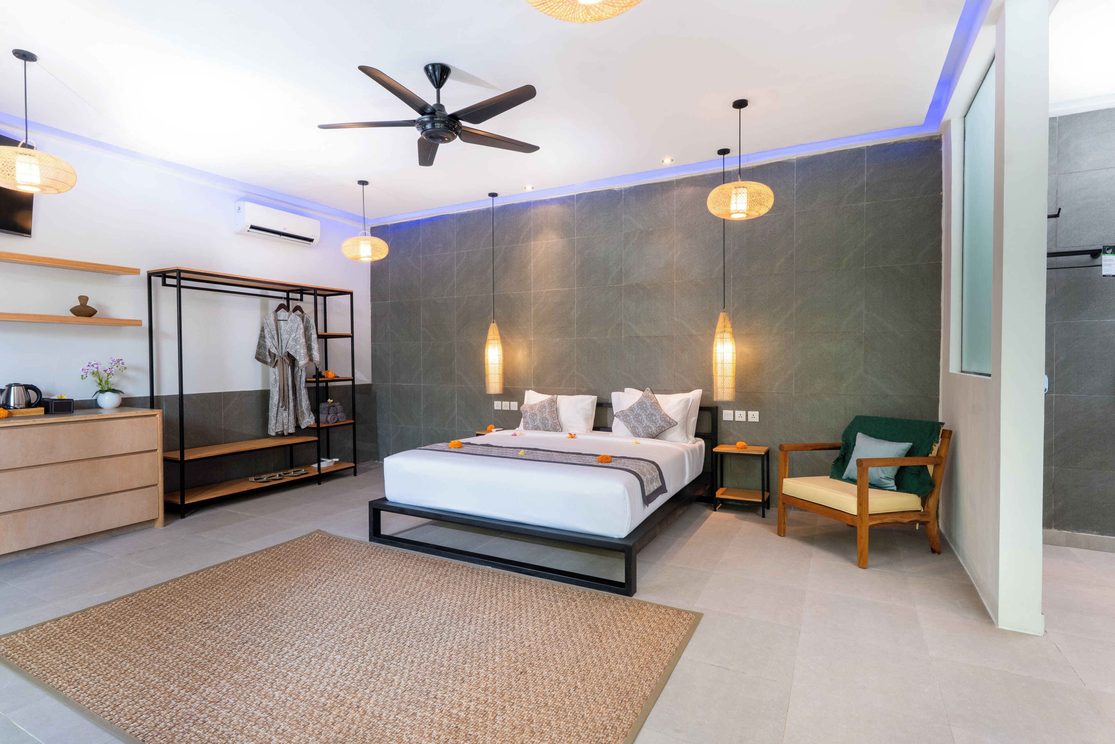 A modern bedroom with a bed, a ceiling fan, a wardrobe, a chair, and a bedside table.