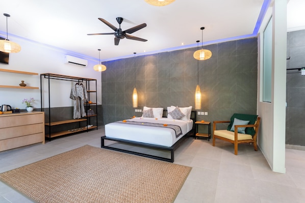 A modern bedroom with a bed, a ceiling fan, a wardrobe, a chair, and a bedside table. - Lula Boutique by The Studios Ubud (Ubud)