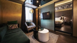 A modern hotel room with a sofa, armchair, and a round coffee table. - Hotel Parkview (Seoul)