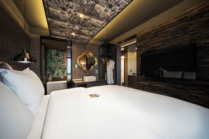 A modern bedroom with a large bed, a vanity with a mirror, and a flat-screen TV mounted on the wall. - Hotel Parkview (Seoul)