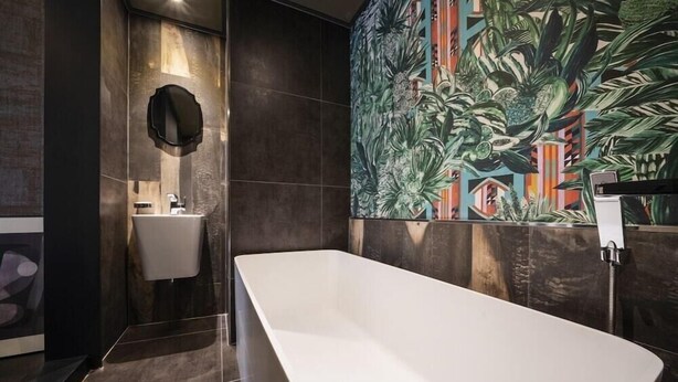 A modern bathroom with a freestanding bathtub, a sink, and a large tropical mural on the wall. - Hotel Parkview (Seoul)