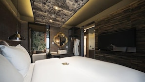 A modern bedroom with a large bed, a mounted TV, a vanity with a mirror, and a ceiling with a botanical mural. - Hotel Parkview (Seoul)