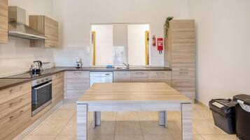 A modern kitchen with a central island, built-in oven, and stainless steel appliances.