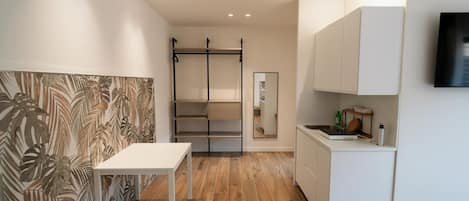 A modern kitchen with white cabinets, a wooden countertop, and a built-in stove.