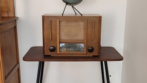 Um rádio de madeira sobre uma mesa, com um globo acima.