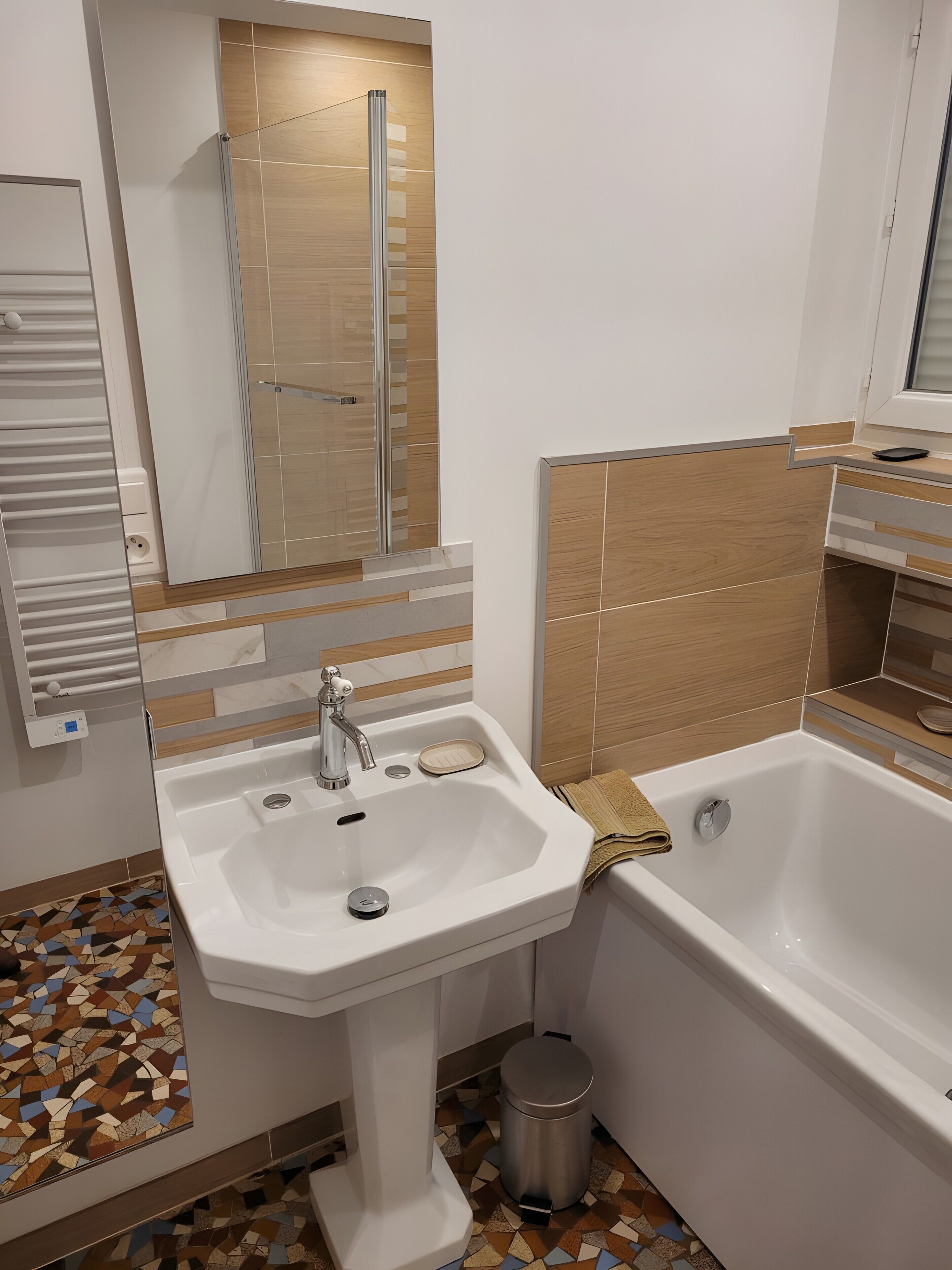 Un bagno moderno con un lavandino bianco, una vasca e uno specchio.