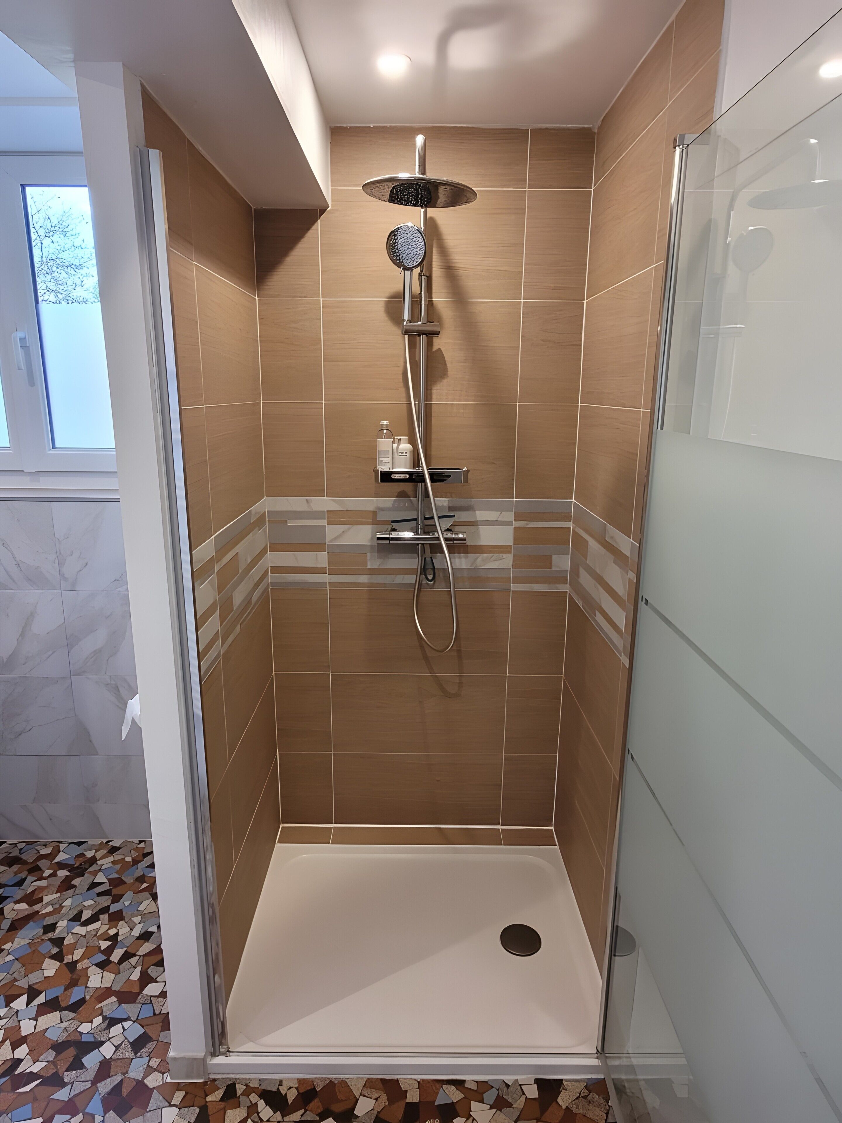 Ducha con cabezal de ducha de mano, grifo empotrado y panel de control.