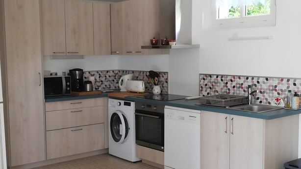 Uma cozinha moderna com eletrodomésticos embutidos, máquina de lavar e lava-louças.