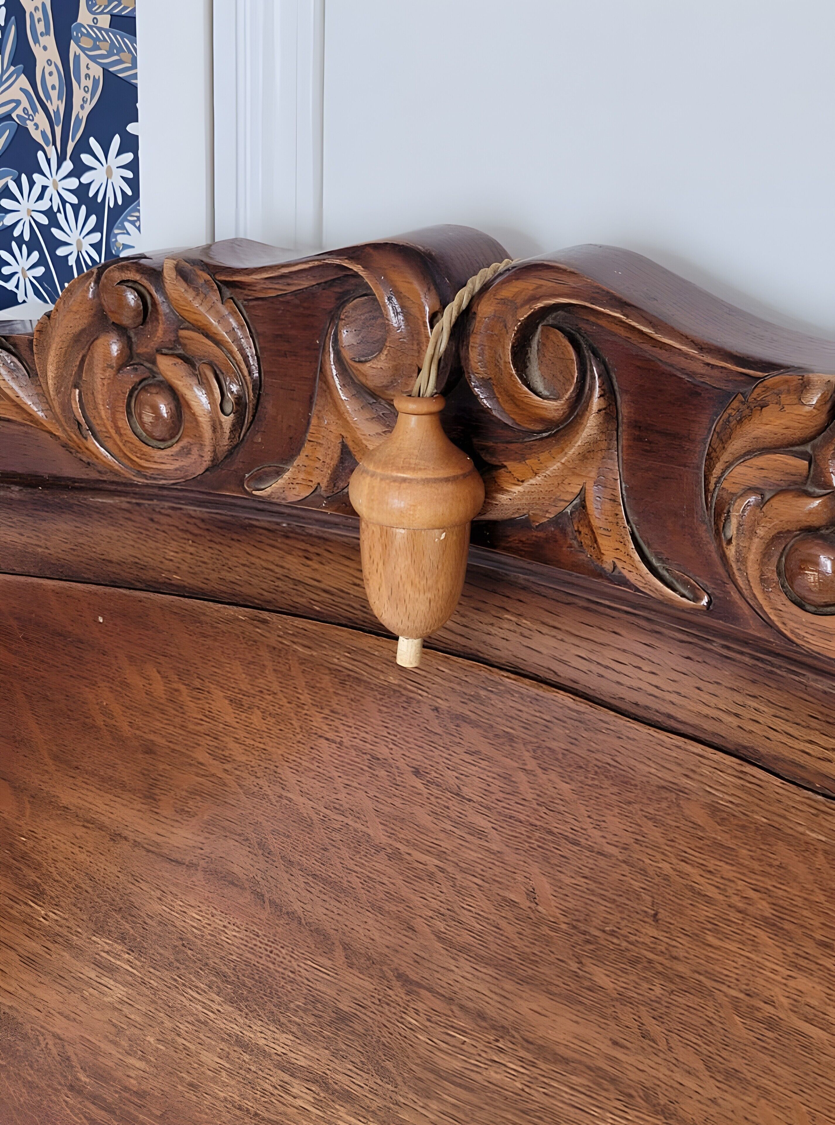 A wooden headboard with intricate carvings and a vase.